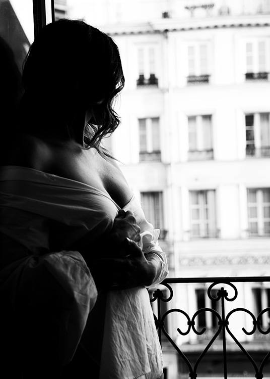 – Svartvitt fotografi av en kvinna som står vid fönstret.