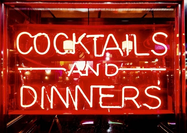 – Neonskylt i klarrött med en restaurang i bakgrunden.