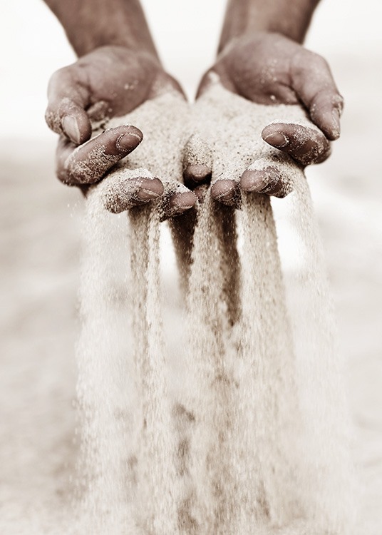  – Fotografi av sand som rinner mellan fingrarna