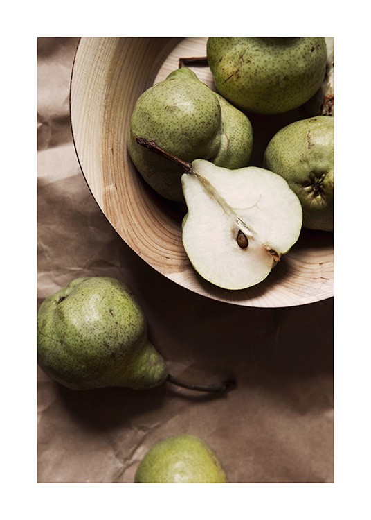 Gröna päron som ligger i en ljusbrun träskål 
