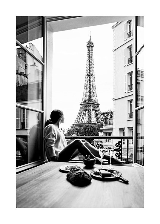 Svartvitt foto från Paris med kvinna i ett fönster och Eiffeltornet i bakgrunden