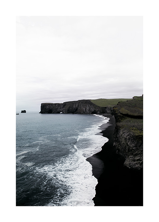  - Fotografi av kust med svarta klippor, svart strand och havsvågor
