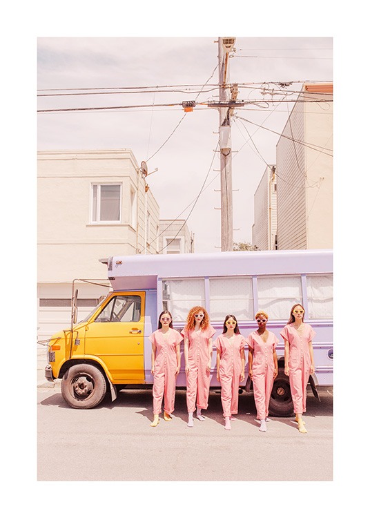 - Foto av tjejer iklädda rosa overaller som står framför en buss målad i ljuslila och gult