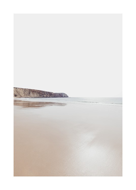  – Foto av en kustlinje med ett hav och en klippa i bakgrunden