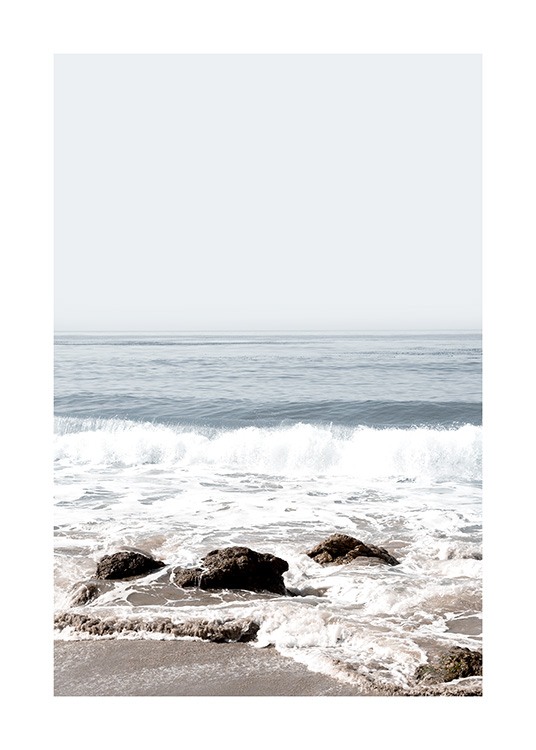  – Foto av vågor som rullar in över en strand med stenar