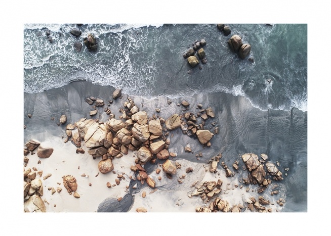  – Foto ovanifrån av en kust med stenar och klippblock på stranden