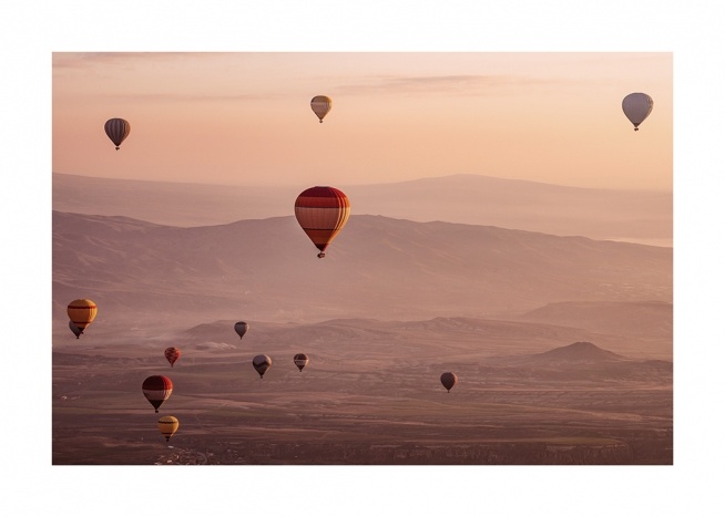  - Fotografi av ett landskap i solnedgång med luftballonger i luften