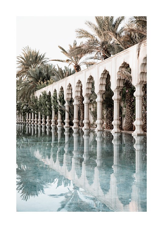  - Fotografi av vita pelare och vågiga valv bredvid en pool med palmer i bakgrunden