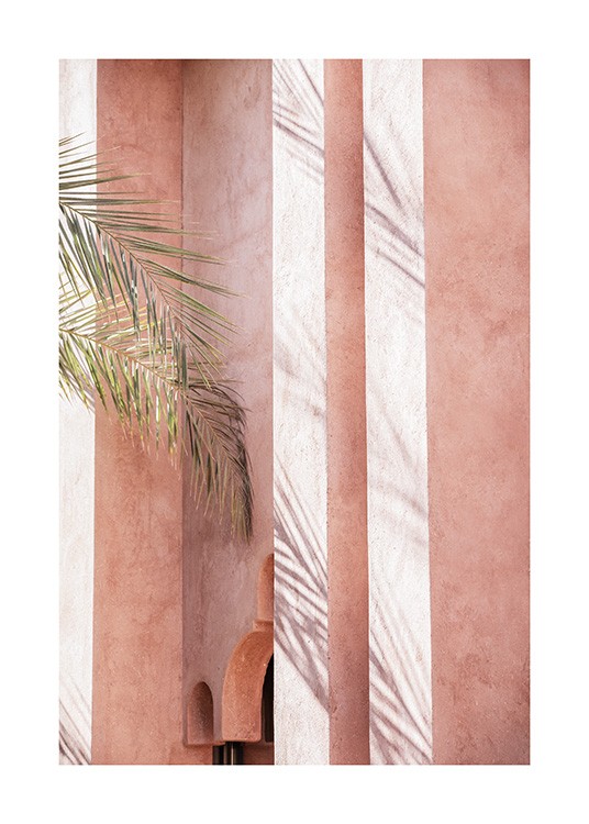  - Fotografi av palmblad som vilar mot en rosa byggnad