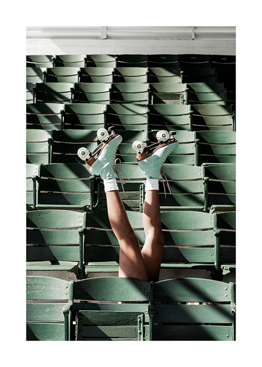  – Fotografi av en person som bär rullskridskor och sträcker upp benen mellan gröna sittplatser på en arena