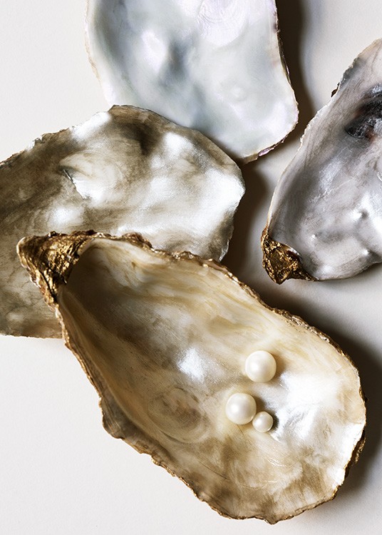  – Fotografi av ostronskal i silver och guld med vita pärlor inuti skalet