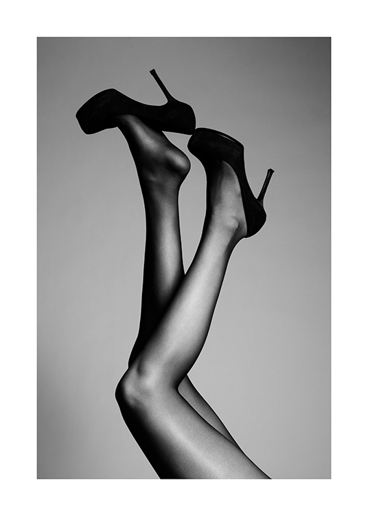  – Svartvitt fotografi av ett par ben uppsträckta i luften, med svarta högklackade skor