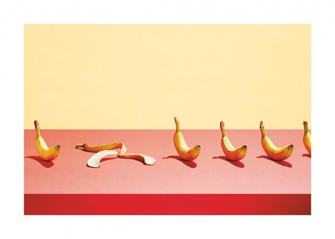 – Fotografi av en rad med bananer som ligger på ett rosa bord med en gul bakgrund