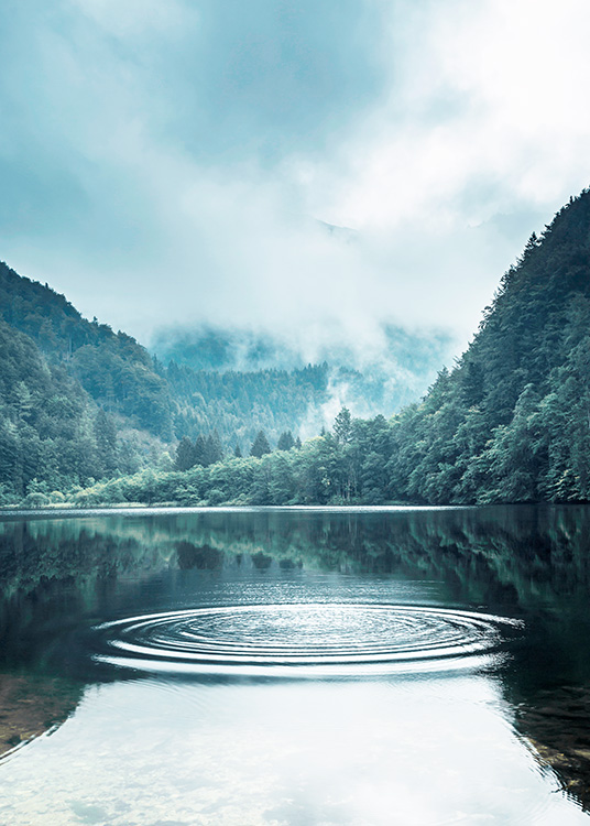  – Fotografi av ringar på vattnet i en sjö, men en stor skog och dimma i bakgrunden