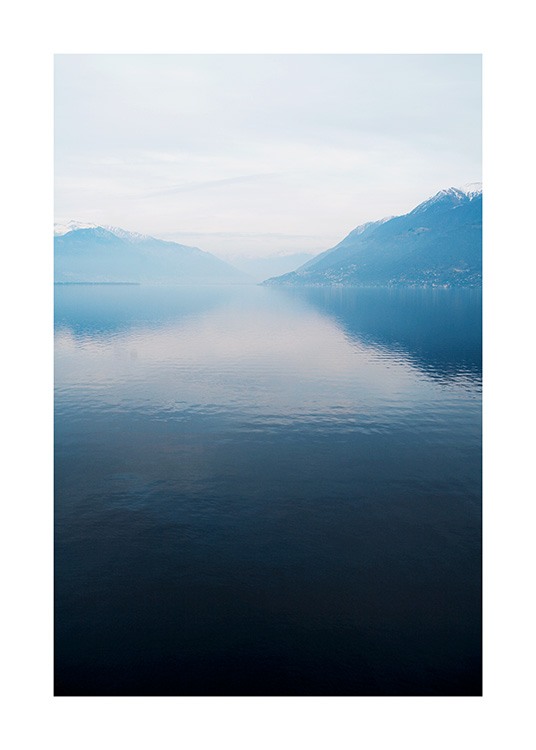  – Fotografi av en sjö med en stilla yta, med berg och dimma i bakgrunden