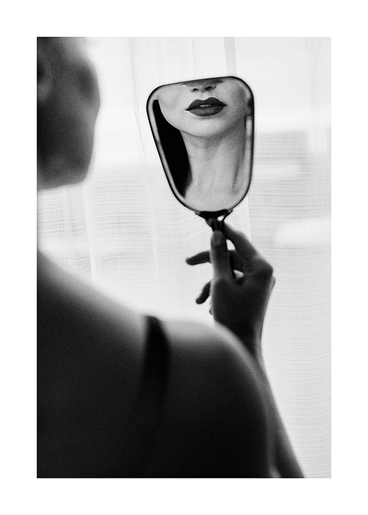  – Svartvitt fotografi av en kvinna som tittar på sig själv med mörkt läppstift i en liten spegel