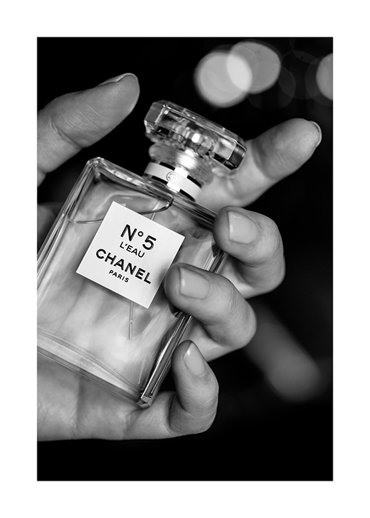  – Svartvitt fotografi av en flaska Chanel No5 parfym i en hand