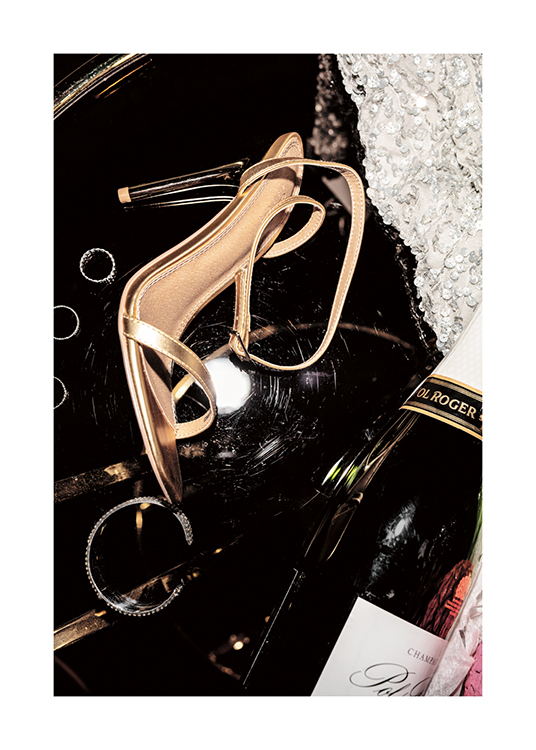  – Ett foto av champagne, guldklackar, silversmycken och en paljettklänning
