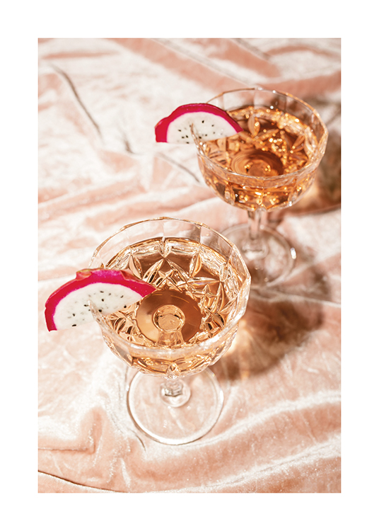  – Ett fotografi av två cocktails med roséchampagne i kristallglas med drakfruktskivor