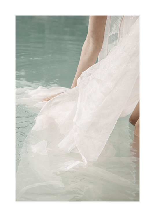  – Fotografi av en person som står i vatten med ett vitt tyg som flyter runtom