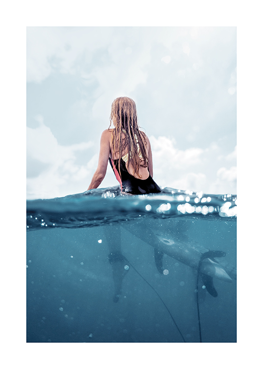  – Fotografi av en kvinna som sitter på en surfbräda på havet, sedd bakifrån