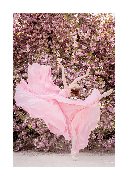  – Fotografi av en ballerina klädd i rosa klänning, i en danspose framför en rosa blomstervägg