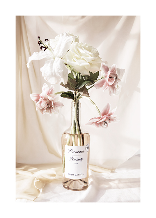  – Fotografi av en bukett med rosa och vita blommor i en flaska rosé