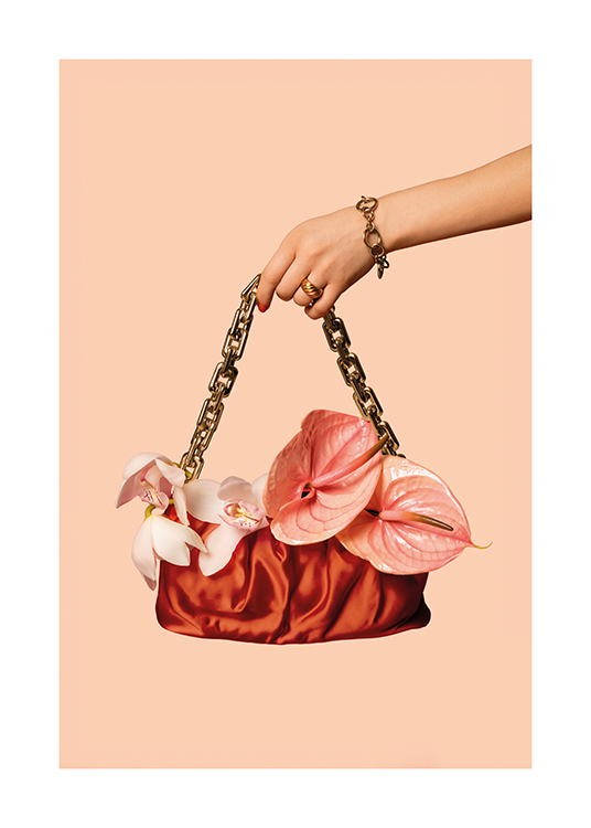  – En kvinna som håller i en handväska prydd med blommor