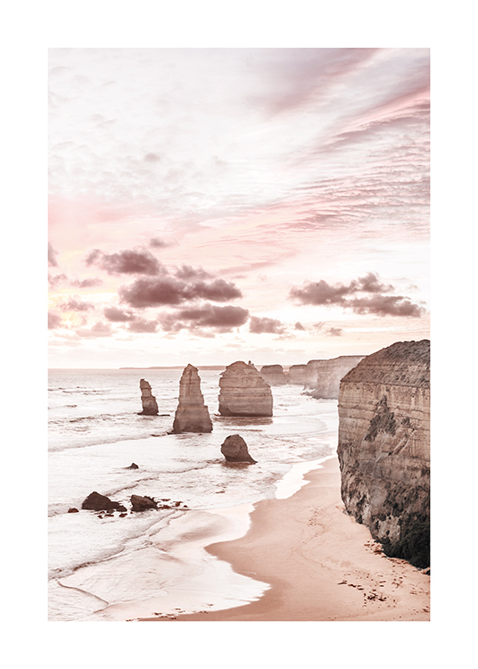  – Fotografi av klippor i och vid havet med en pastellrosa himmel bakom klipporna