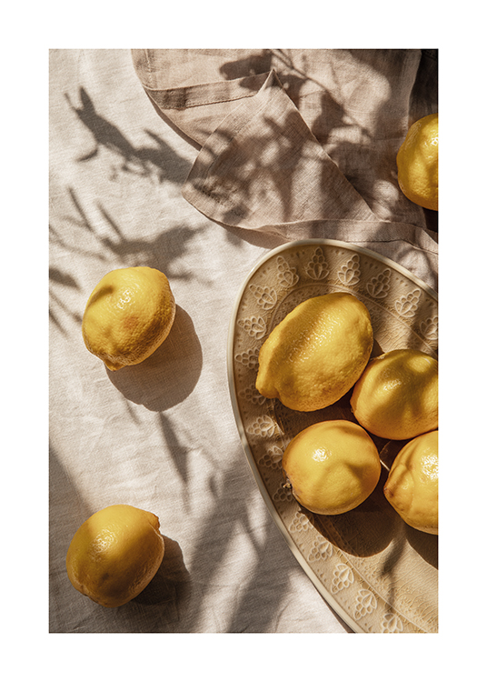  – En tallrik med nyplockade citroner på ett matbord