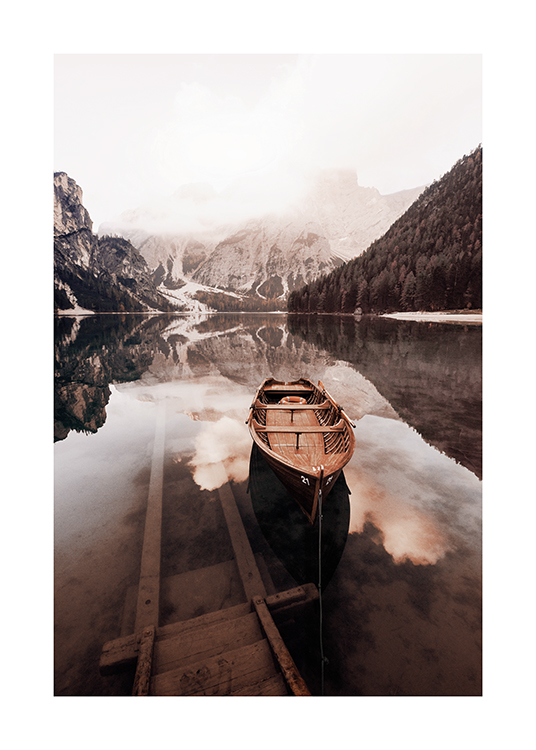  – Fotografi av en stilla sjö med en liten träbåt och snötäckta berg i bakgrunden