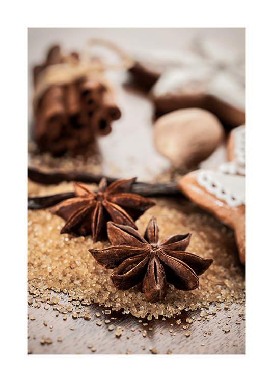  – Fotografi av kanelstänger och stjärnanis som ligger på brunt socker