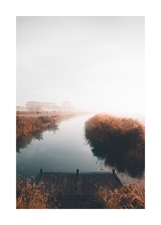  – Fotografi av en lugn sjö med ett dimmigt landskap i bakgrunden och en liten brygga i förgrunden