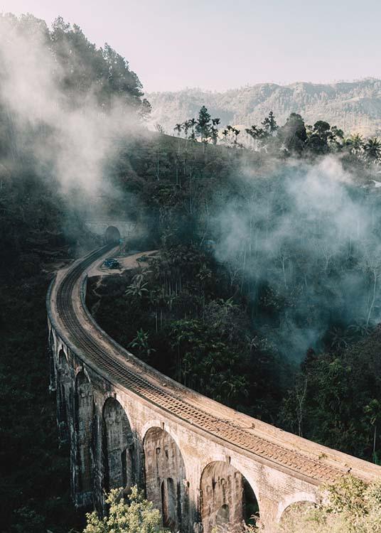  – Fotografi av en bro som går genom ett landskap med träd och dimma